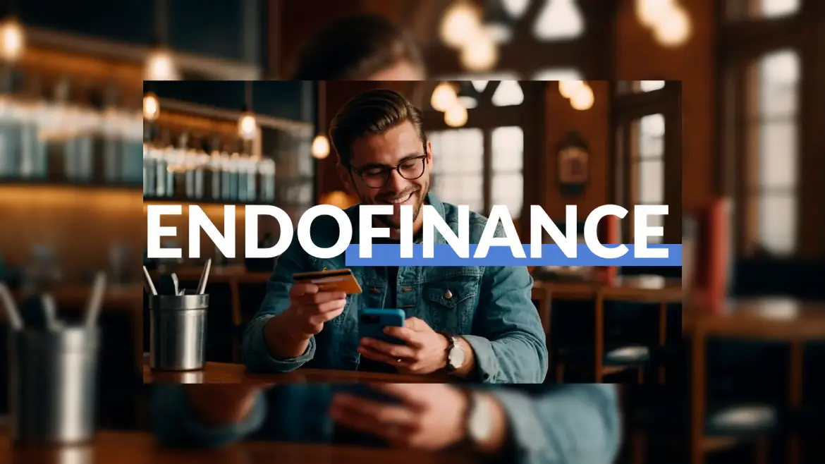 Um homem segurando seu cartão de crédito e seu celular.